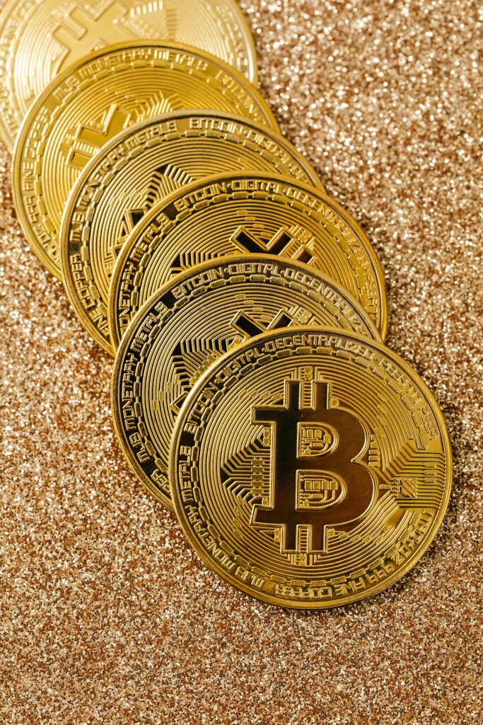 Golden Bitcoin cryptocurrency coins stacked on a glittering surface representing digital wealth and blockchain.